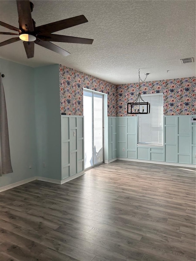 3031 San Jacinto Cir Unit 3031, Sanford, FL 32771 - unfurnished room with wallpapered walls, wood finished floors, a textured ceiling, ceiling fan, and a wainscoted wall