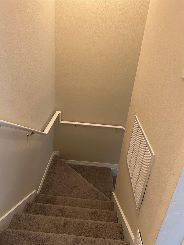 stairs featuring carpet flooring