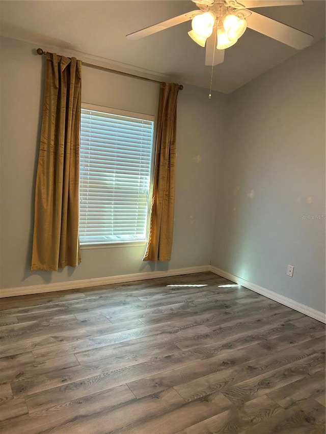 unfurnished room with ceiling fan and dark wood-type flooring