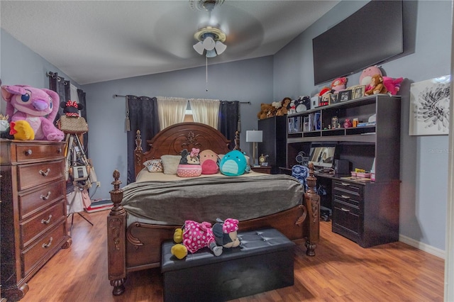 bedroom with ceiling fan, light wood-type flooring, and vaulted ceiling