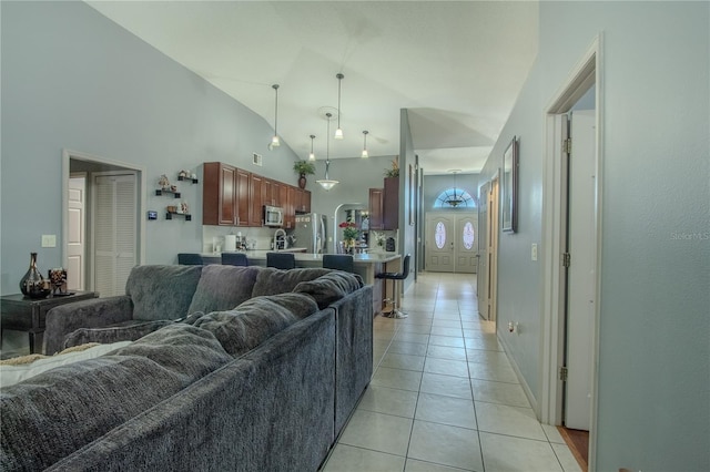 living room featuring light tile patterned floors and high vaulted ceiling