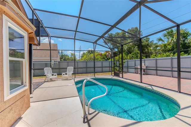 view of swimming pool with glass enclosure and a patio area