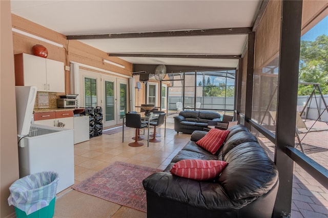 living room with vaulted ceiling with beams, light tile patterned flooring, and french doors