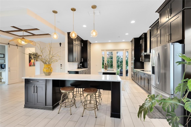 kitchen with a kitchen breakfast bar, tasteful backsplash, coffered ceiling, light hardwood / wood-style floors, and hanging light fixtures