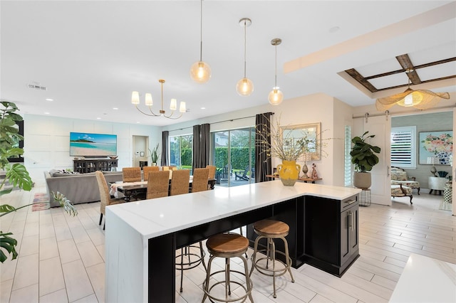 kitchen with a breakfast bar, pendant lighting, a chandelier, and a kitchen island