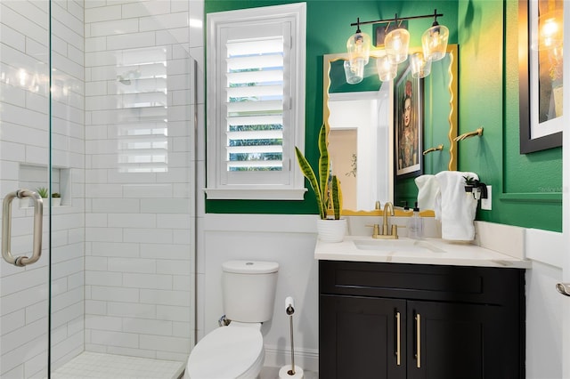 bathroom featuring an enclosed shower, vanity, and toilet