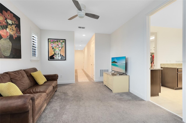 living room with ceiling fan and light colored carpet