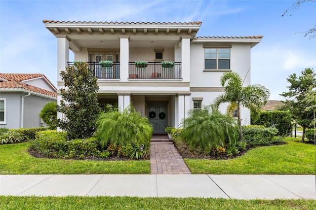 mediterranean / spanish home with a balcony and a front yard