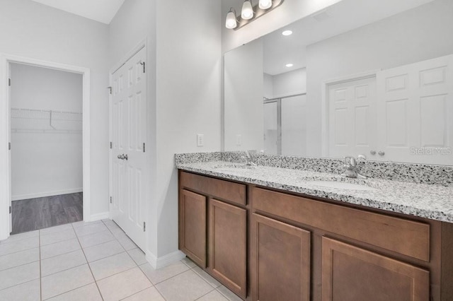 bathroom with tile patterned flooring, vanity, and walk in shower