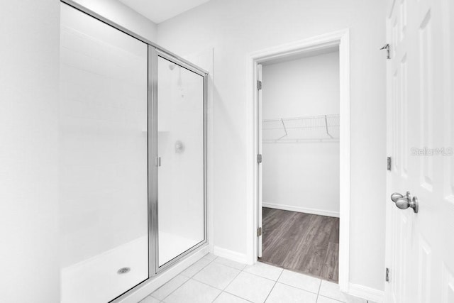 bathroom featuring hardwood / wood-style flooring and a shower with shower door