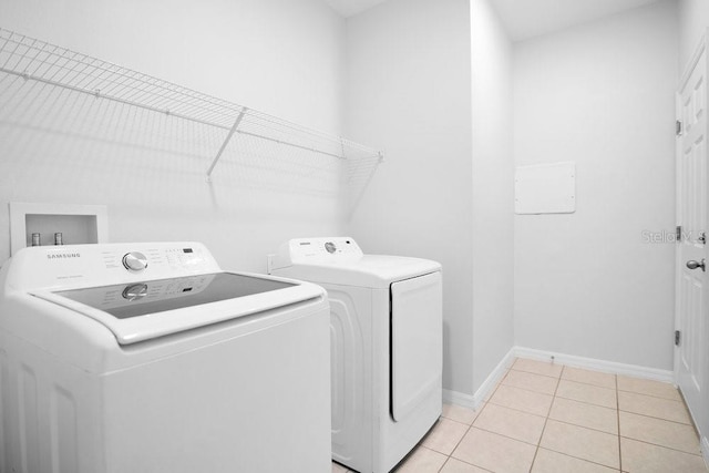 washroom featuring light tile patterned floors and washing machine and dryer