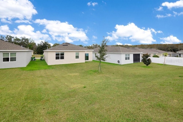 rear view of house featuring a lawn