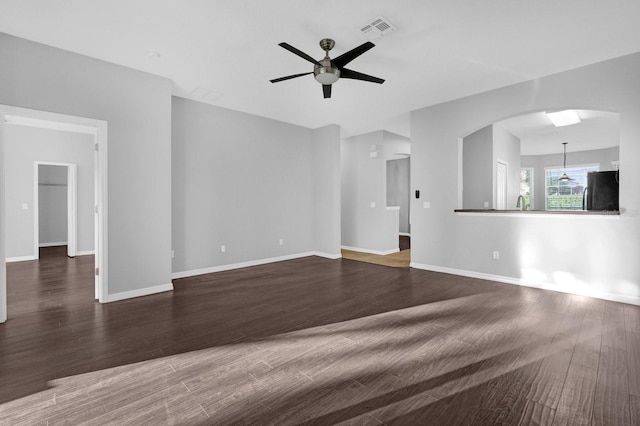 unfurnished living room with ceiling fan and dark hardwood / wood-style flooring