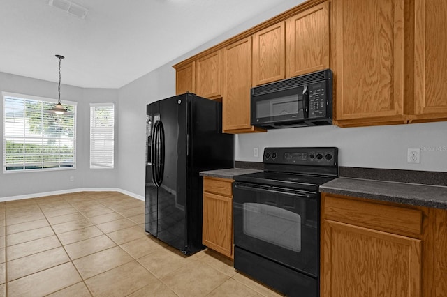 kitchen featuring hanging light fixtures, light tile patterned floors, and black appliances