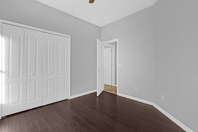 unfurnished bedroom featuring a closet, ceiling fan, and dark hardwood / wood-style flooring