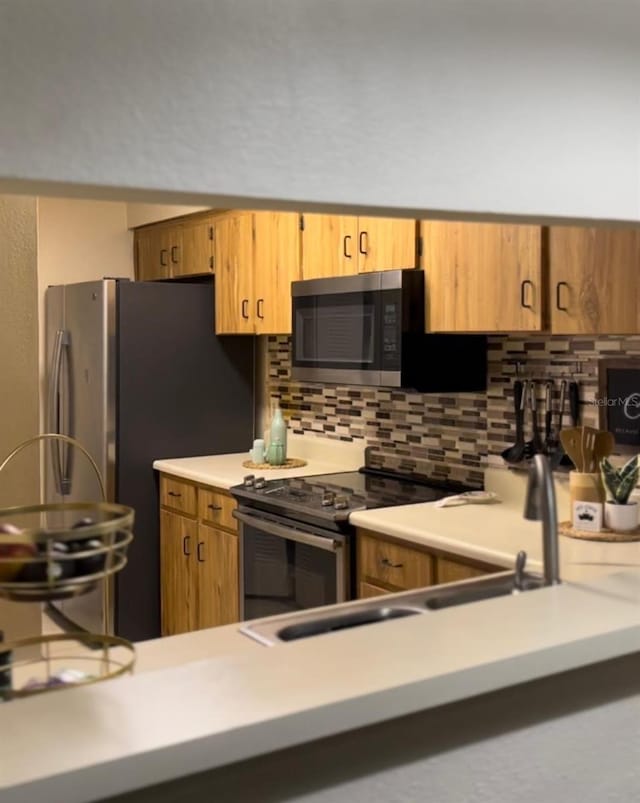 kitchen featuring stainless steel appliances and tasteful backsplash