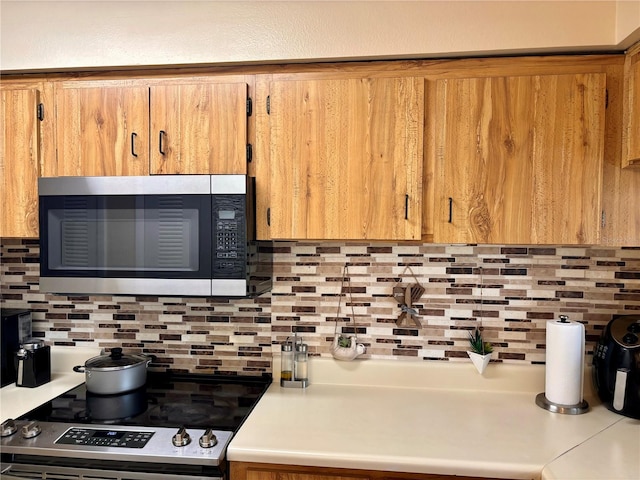 kitchen with appliances with stainless steel finishes and tasteful backsplash