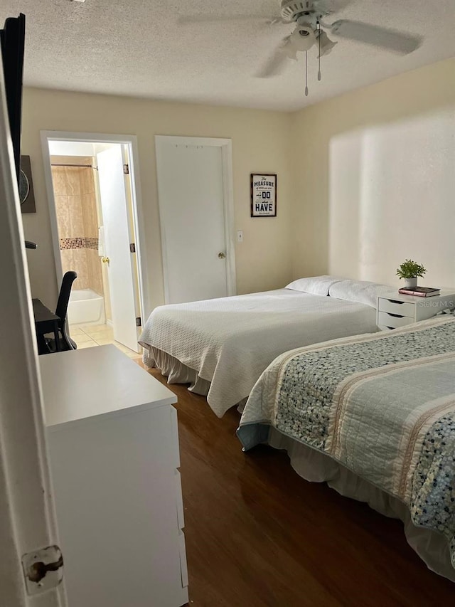 bedroom featuring a textured ceiling, dark hardwood / wood-style floors, ceiling fan, and ensuite bathroom