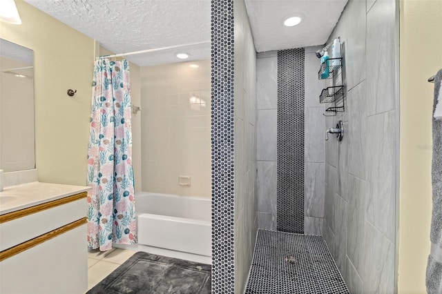 bathroom featuring tile patterned floors, shower / tub combo with curtain, vanity, and a textured ceiling