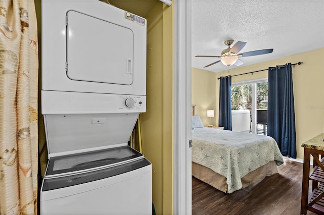 laundry area featuring a textured ceiling, hardwood / wood-style flooring, ceiling fan, and stacked washer / drying machine