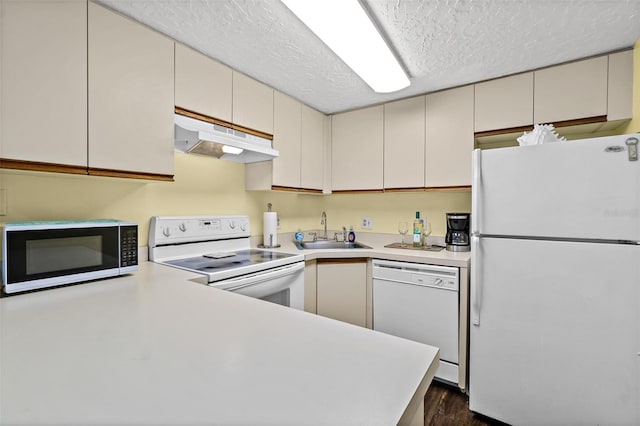 kitchen featuring kitchen peninsula, a textured ceiling, white appliances, dark wood-type flooring, and sink