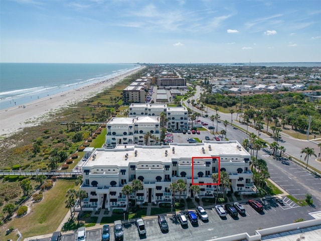 birds eye view of property with a water view and a beach view