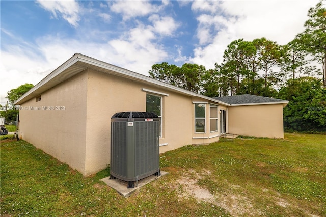 back of house featuring a yard and cooling unit