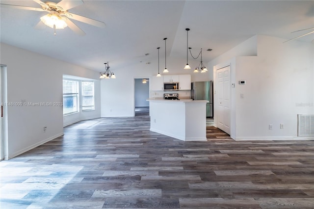 kitchen with white cabinets, appliances with stainless steel finishes, hanging light fixtures, and lofted ceiling