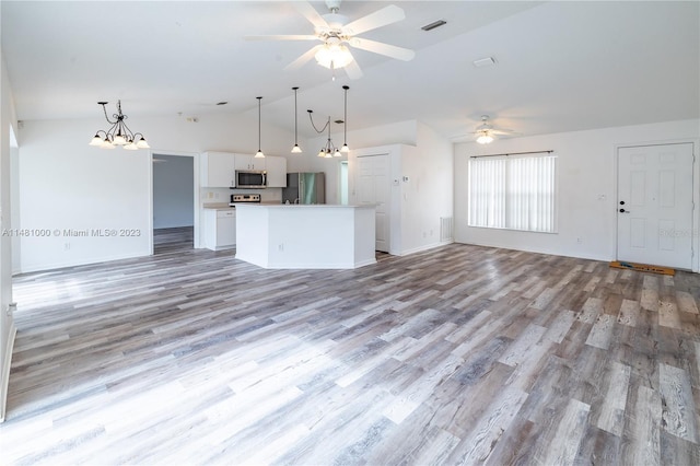 kitchen featuring appliances with stainless steel finishes, light wood-type flooring, decorative light fixtures, and white cabinetry