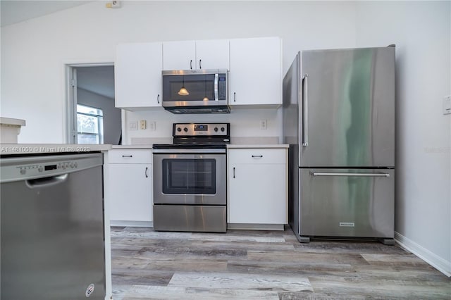 kitchen featuring lofted ceiling, light wood-type flooring, white cabinetry, and appliances with stainless steel finishes