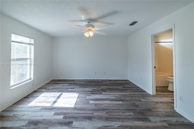 unfurnished room featuring ceiling fan, dark wood-type flooring, and a textured ceiling