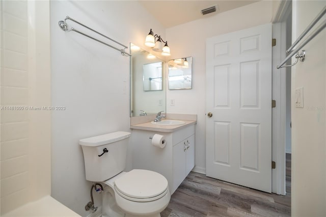 bathroom with hardwood / wood-style floors, vanity, and toilet