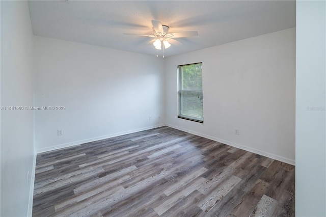 spare room with ceiling fan and dark wood-type flooring