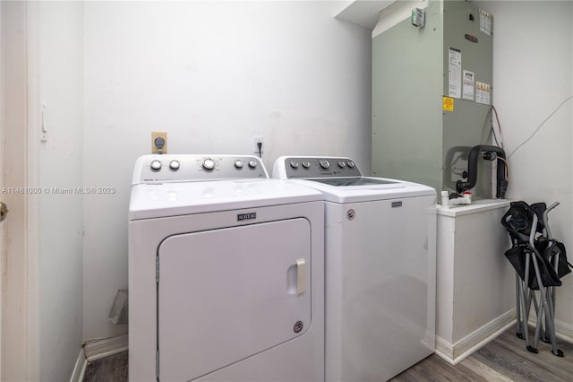 washroom with washing machine and dryer, heating unit, and hardwood / wood-style flooring