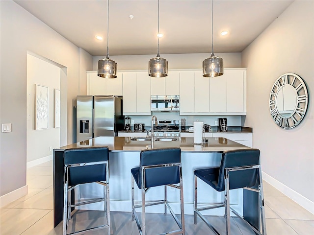 kitchen with a kitchen island with sink, sink, white cabinets, and stainless steel appliances