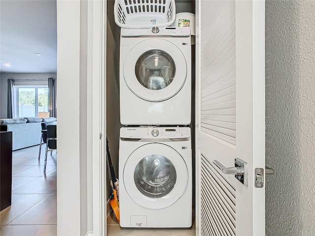 laundry area with tile patterned flooring and stacked washer and dryer