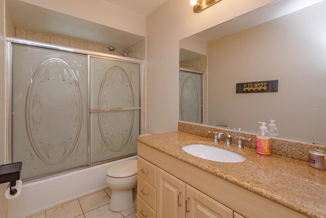 full bathroom featuring combined bath / shower with glass door, vanity, tile patterned floors, and toilet