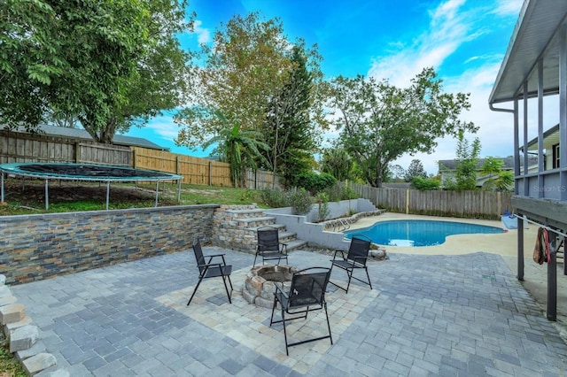 view of swimming pool featuring a trampoline and a patio