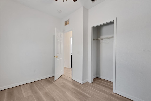 unfurnished bedroom with light hardwood / wood-style flooring, a closet, and ceiling fan