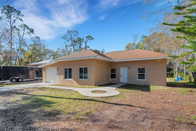 ranch-style home featuring a garage and a front lawn