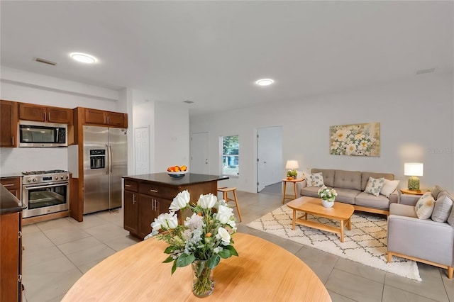 kitchen with light tile patterned floors, stainless steel appliances, and a center island