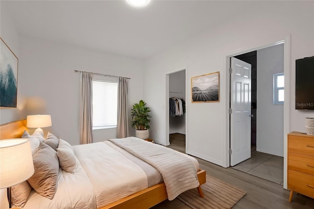 bedroom with a spacious closet, a closet, and light wood-type flooring