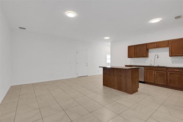 kitchen with a center island, sink, dishwasher, and light tile patterned floors