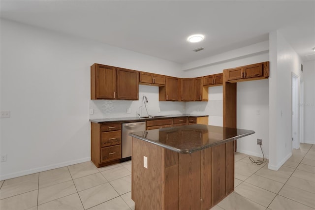 kitchen featuring sink, light tile patterned floors, dishwasher, a kitchen island, and backsplash