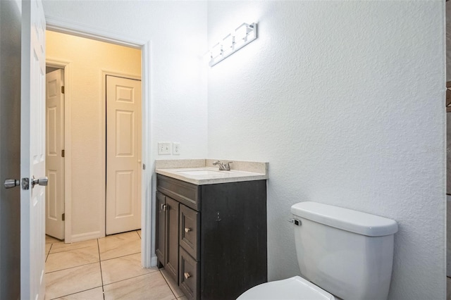 bathroom featuring vanity, tile patterned floors, and toilet