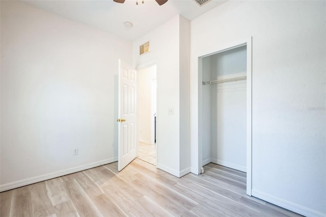 unfurnished bedroom featuring ceiling fan, light hardwood / wood-style floors, and a closet