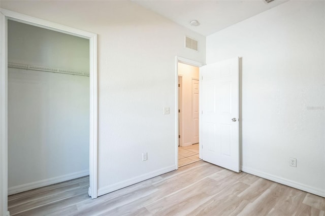 unfurnished bedroom featuring a closet and light wood-type flooring