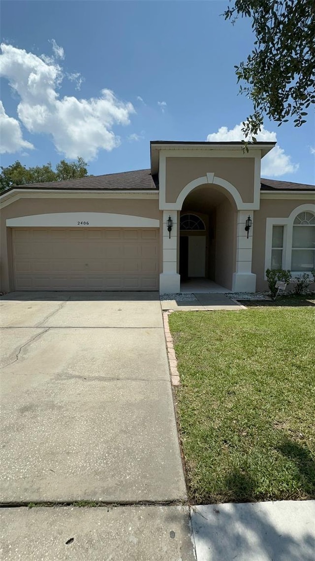 view of front of house featuring a garage and a front lawn