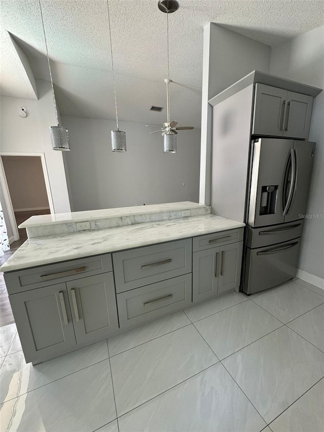 kitchen featuring a textured ceiling, gray cabinets, ceiling fan, and stainless steel refrigerator with ice dispenser