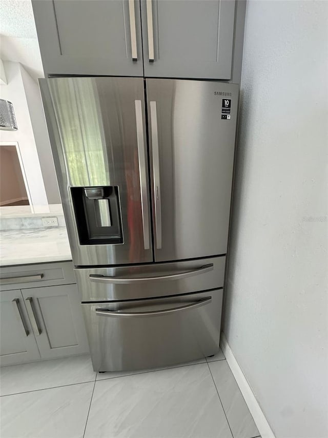 room details with stainless steel refrigerator with ice dispenser and gray cabinets